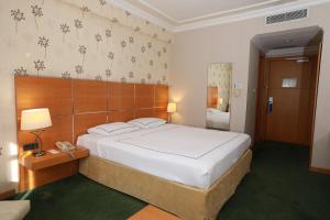 A bed or beds in a room at Anemon Grand Manisa Otel