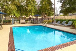 a large blue swimming pool with chairs and tables at Courtyard by Marriott New Orleans Metairie in Metairie