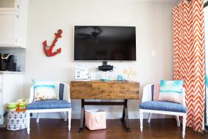 a living room with two chairs and a television on a wall at CDM 314 - Buoy Oh Buoy! in Galveston