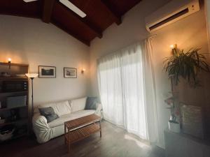 ein Wohnzimmer mit einem Sofa und einem großen Fenster in der Unterkunft Casita independiente con jardin in Cercedilla