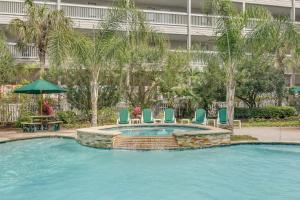 - une piscine avec des chaises, une table et un parasol dans l'établissement CDM 314 - Buoy Oh Buoy!, à Galveston