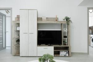 Cozy ApartHotel Suceava في سوسيفا: غرفة معيشة مع تلفزيون في مركز ترفيهي خشبي