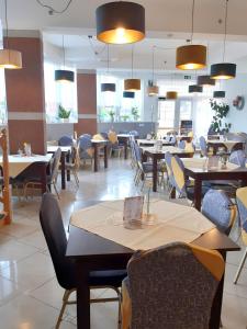 a dining room with tables and chairs and lights at Rezydencja Korab in Międzyzdroje