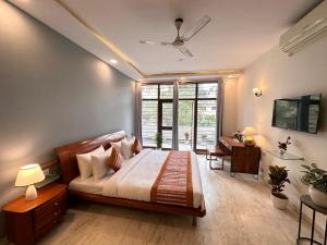 a bedroom with a bed and a desk and a window at Grove Residency Hauz Khas New Delhi Couple Friendly in New Delhi