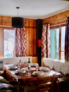 - une table à manger avec une bouteille de vin dans l'établissement Appartement skis aux pieds, à Peisey Vallandry, à Landry