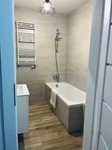 a bathroom with a bath tub and a sink at MHL Apartament Lublin in Lublin