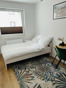 a bed in a room with a window and a rug at MHL Apartament Lublin in Lublin