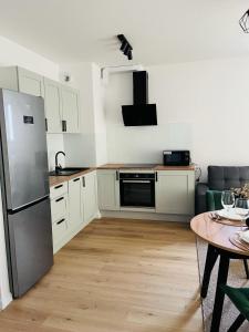 a kitchen with white cabinets and a stainless steel refrigerator at MHL Apartament Lublin in Lublin