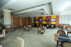 a dining room with tables and chairs and televisions at Anemon Grand Manisa in Manisa
