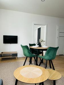 a dining room with a table and green chairs at MHL Apartament Lublin in Lublin