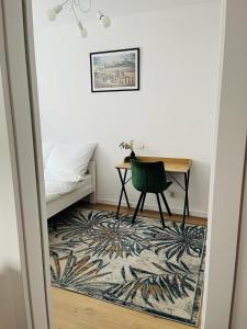 a bedroom with a desk and a green chair at MHL Apartament Lublin in Lublin