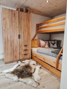 a bedroom with a bunk bed and a rug at Jelení dřevěnice s vlastní vířivkou in Horní Halže