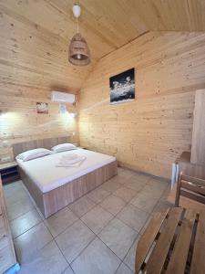 a bedroom with a bed in a wooden room at Cazare Nicoleta in Vadu