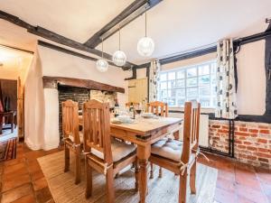 a dining room with a wooden table and chairs at Dukes Lodge in Kersey