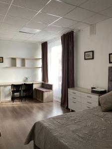 a bedroom with a bed and a desk and a table at Green Kitchen Apartments in Mukacheve