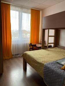 - une chambre avec un lit, un bureau et une fenêtre dans l'établissement Green Kitchen Apartments, à Moukatcheve