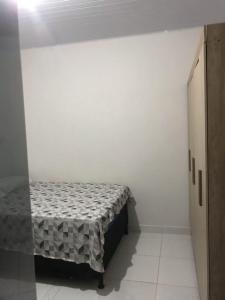 een kleine witte kamer met een bed erin bij Studio Trivion- Px ao centro e praias in Palmas