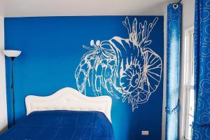 - une chambre bleue dotée d'un lit avec un mur bleu dans l'établissement Bluvilla Sattahip, à Sattahip