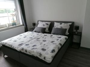 a bedroom with a bed with a floral comforter at Ferienwohnung Gebel - nur für Urlaubsgäste - 55177 in Busboomsfehn