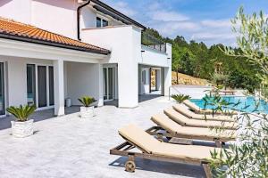 patio z leżakami i basenem w obiekcie Villa Bella Draguc w mieście Korelići