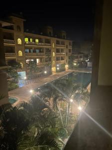- une vue sur un hôtel la nuit avec une piscine dans l'établissement Formosa siolim, à Vieux-Goa