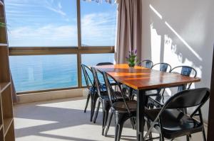 une table et des chaises dans une chambre avec une grande fenêtre dans l'établissement GEMELOS 10 Levante Beach, à Benidorm