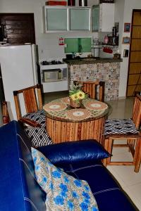 a kitchen with a table with chairs and a counter top at Casa para Temporada Lençóis Ville in Barreirinhas