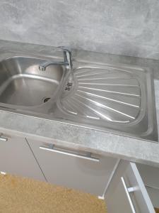 a stainless steel sink with a faucet on a counter at Ubytovna Moravan Brno in Brno