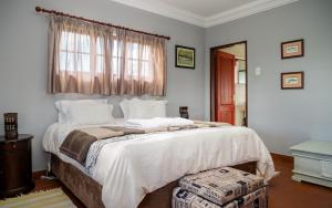 Un dormitorio con una cama grande y una ventana en Moonlight Meadows just outside Dullstoom en Dullstroom