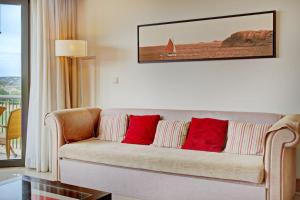sala de estar con sofá y almohadas rojas en Vilamoura Prime @ The Residences at Victoria, en Quarteira