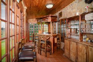 - un bar dans une pièce dotée de murs en bois et de fenêtres dans l'établissement Moonlight Meadows just outside Dullstoom, à Dullstroom