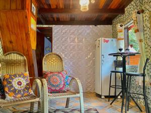 Cette chambre comprend deux chaises et un réfrigérateur. dans l'établissement Alto na Montanha Chalé 1, à Visconde de Mauá