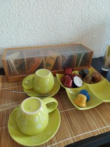 a tray of tea sets and cups on a table at BNB Les Prises in Les Ponts-de-Martel