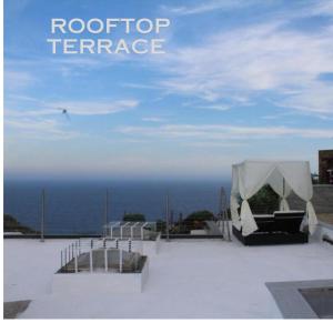 a roof top terrace with a tent and the ocean at Villa CliCla - Pool, sea,hommock swing and laziness in Imperia
