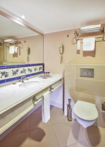a bathroom with a sink and a toilet and a mirror at Anemon Hotel Izmir in Izmir