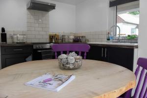 普里茅斯的住宿－LUCKY TOR，厨房配有带紫色椅子的木桌