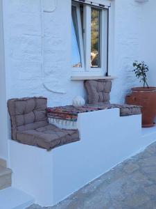 un canapé installé devant une fenêtre dans l'établissement Helens Mountain House, à Samos