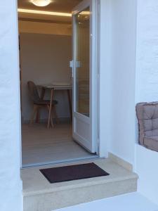 une porte ouverte menant à une chambre avec une table dans l'établissement Helens Mountain House, à Samos