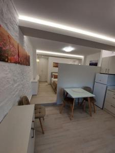 Cet appartement comprend une chambre avec une table et une cuisine. dans l'établissement Helens Mountain House, à Samos