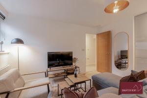 a living room with a couch and a tv at Wokingham - 2 Bedroom - Refurbished 1st Floor Flat in Wokingham