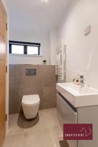 a bathroom with a white toilet and a sink at Wokingham - 2 Bedroom - Refurbished 1st Floor Flat in Wokingham