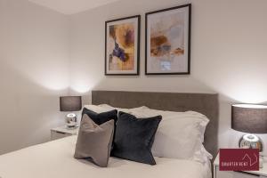 a bedroom with a bed with three pictures on the wall at Wokingham - 2 Bedroom - Refurbished 1st Floor Flat in Wokingham