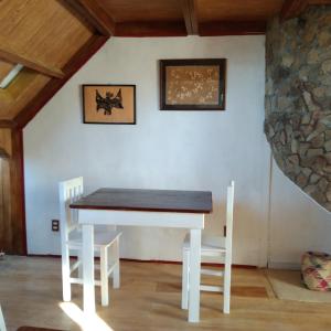 una mesa y sillas en una habitación con una pared de piedra en Casa de campo en Oaxaca, en San Pablo Etla