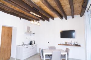 a kitchen and dining room with a table and a tv at Politeama house in Palermo