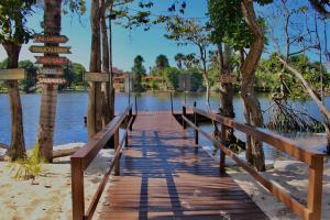 a wooden bridge over a body of water with street signs at Casa para Temporada Lençóis Ville in Barreirinhas