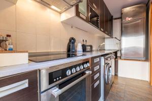 cocina con fogones y lavavajillas en Bettatur Apartament Ripoll, en Tarragona