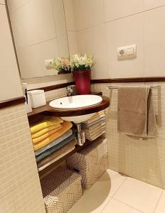 a bathroom with a sink and a mirror and towels at Acogedor Ático en Nigran in Nigrán +25 photos