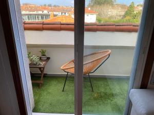 a chair sitting on a balcony with a window at Acogedor Ático en Nigran in Nigrán