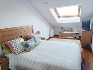 a bedroom with a large bed with a skylight at Acogedor Ático en Nigran in Nigrán