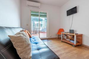 sala de estar con sofá azul y mesa en Bettatur Apartament Ripoll, en Tarragona